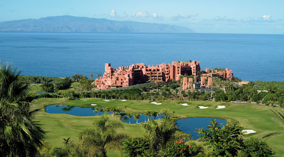 The Ritz-Carlton Abama Resort in Tenerife with golf course, palm trees and lake in front and sea behind