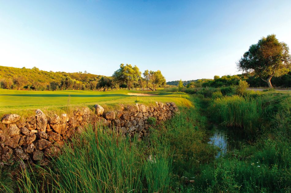 Rocks protecting the fairway against the river at Alamos Golf Course in Portugal
