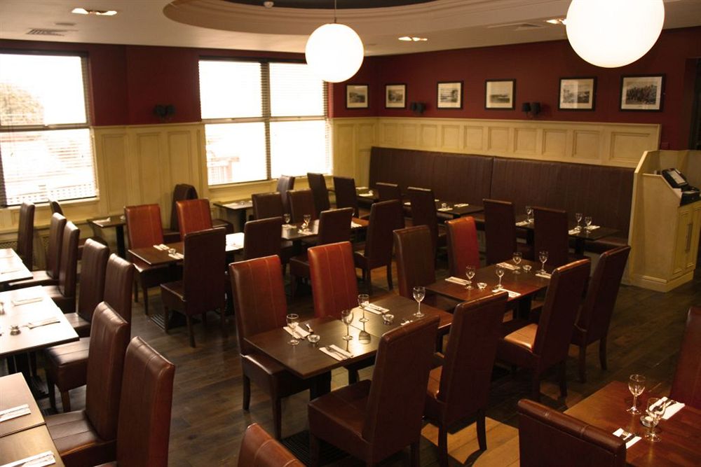 Dining room at Ballyliffin Lodge and Spa Hotel with brown leather chairs and wooden dining tables