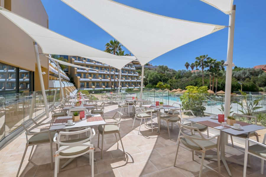 Outdoor dining area by the swimming pool at Barcelo Montecastillo Golf Resort