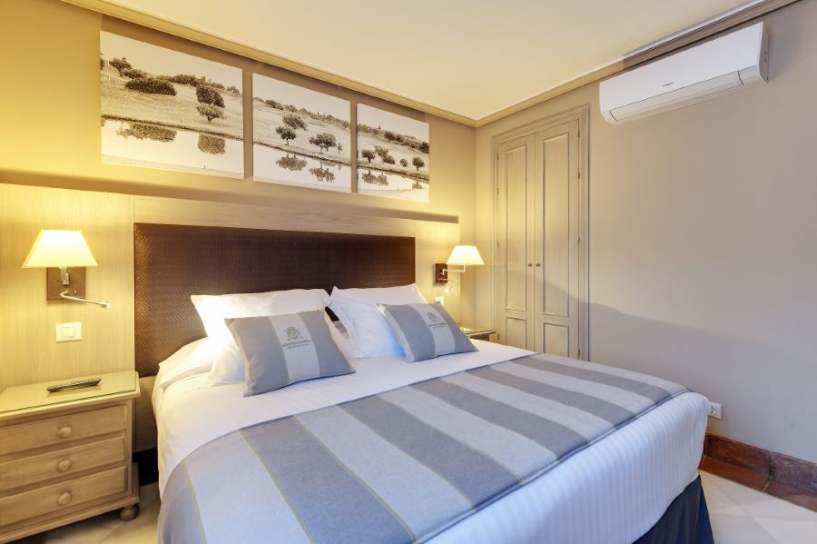 Bedroom with stripey duvet cover at Barcelo Montecastillo Golf Resort