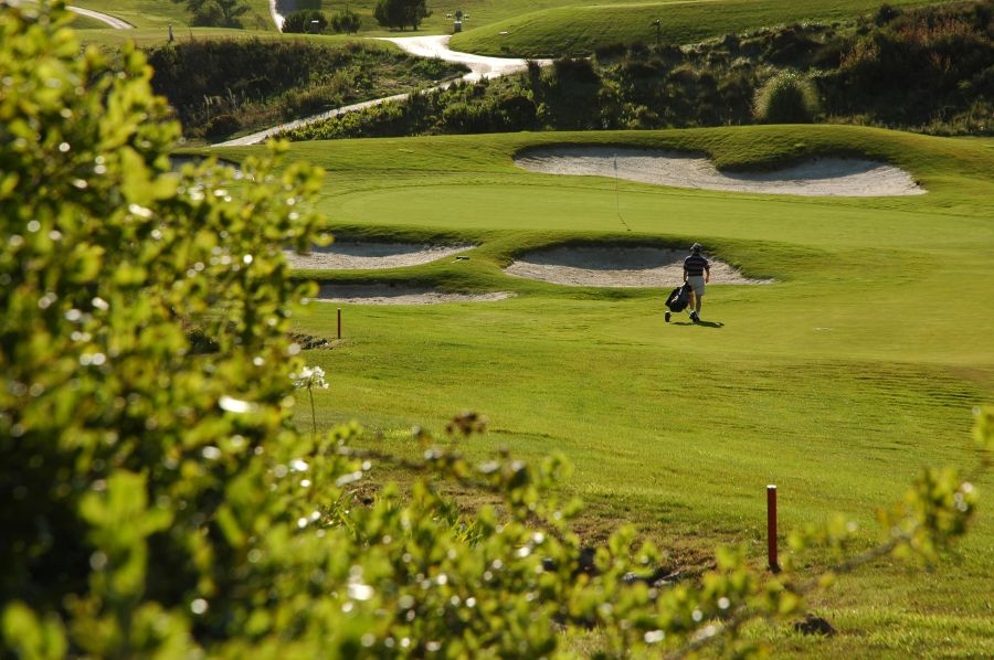 Golfer walking across the fairway at Belas Golf Course