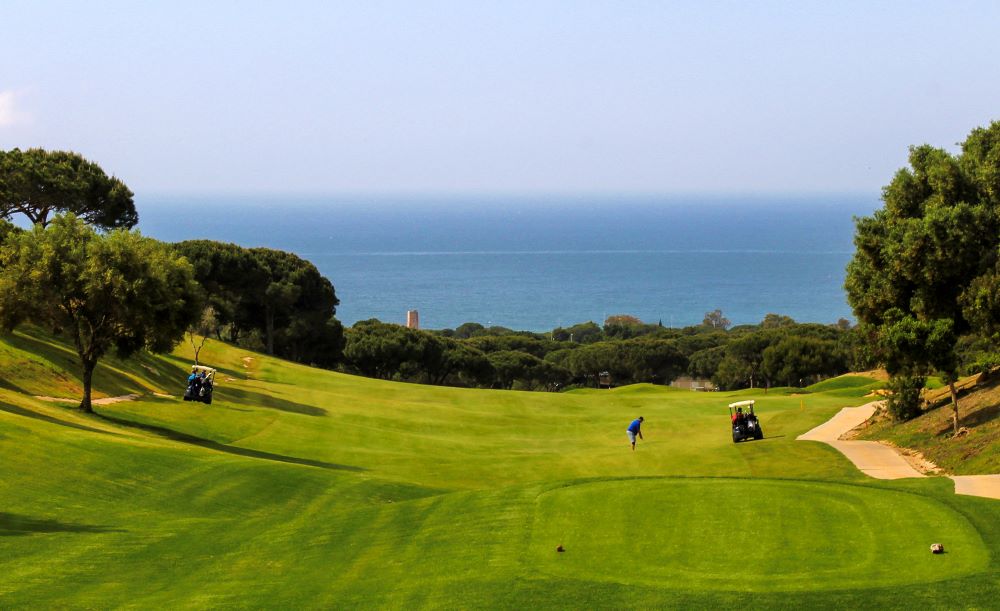 Golfer on the fairway with buggy at Cabopino Golf in Marbella, Costa Del Sol