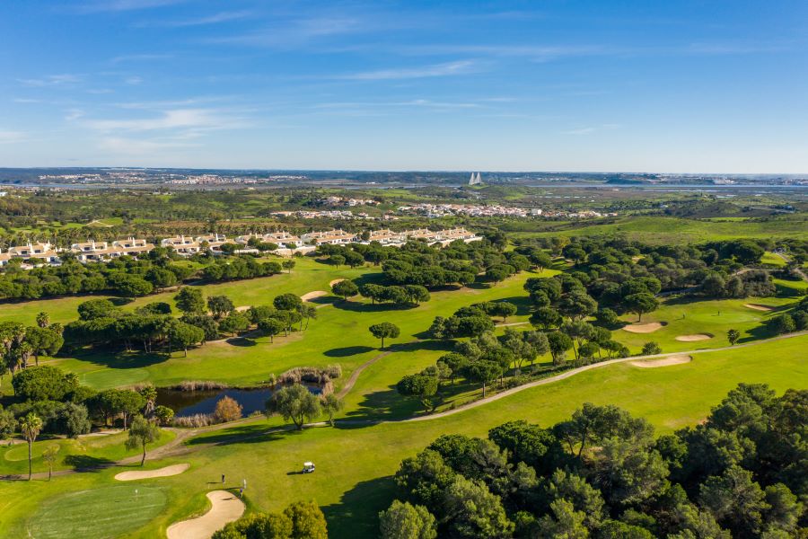 Castro Marim Golf & Country club from the air with multiple fairways and trees lining it