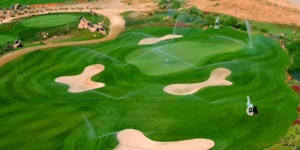 Arial shot of Desert Springs Golf Course in Spain with sprinklers watering the green