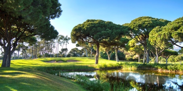 Green trees and blue lake at Dom Pedro Golf Old Course in Vilamoura