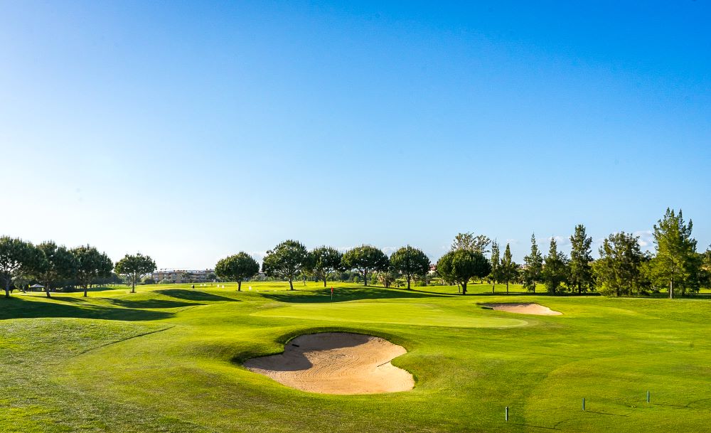 Bunker in front of putting green with trees protecting the rear at Dom Pedro Millennium Golf Course in Vilamoura