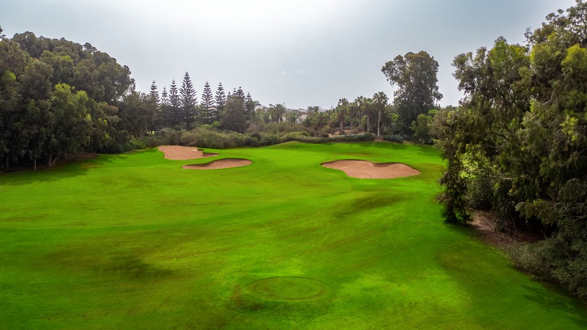 Putting green in the distance protected by three sand bunkers at Golf Les Dunes