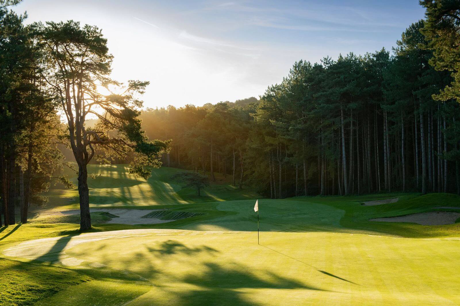 Sunrise over Hardelot's Les Dunes Golf Course on hole 1, with trees protecting the green fairway