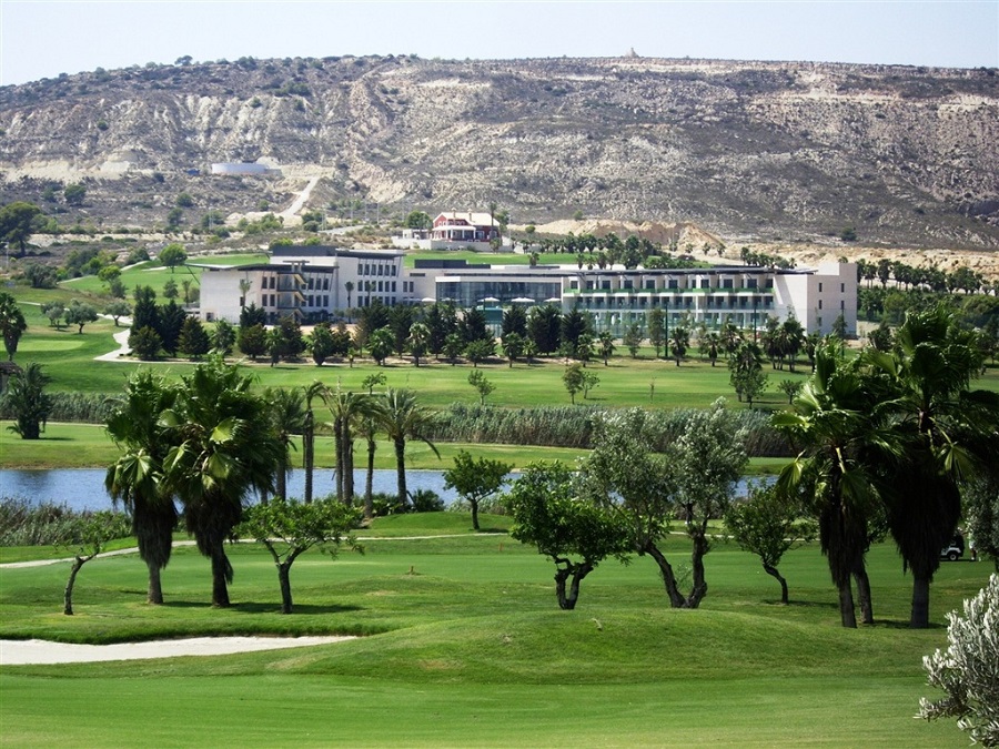Exterior of Hotel La Finca Golf And Spa with golf course, lake and palm trees in the foreground