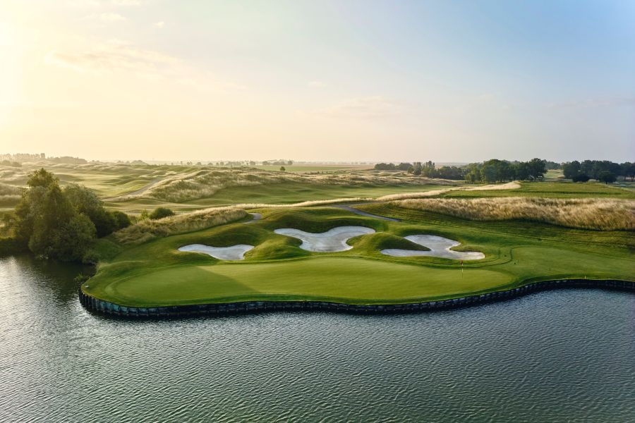 Large lake on one side and white sand bunkers on the other, protecting the green at Le Golf National