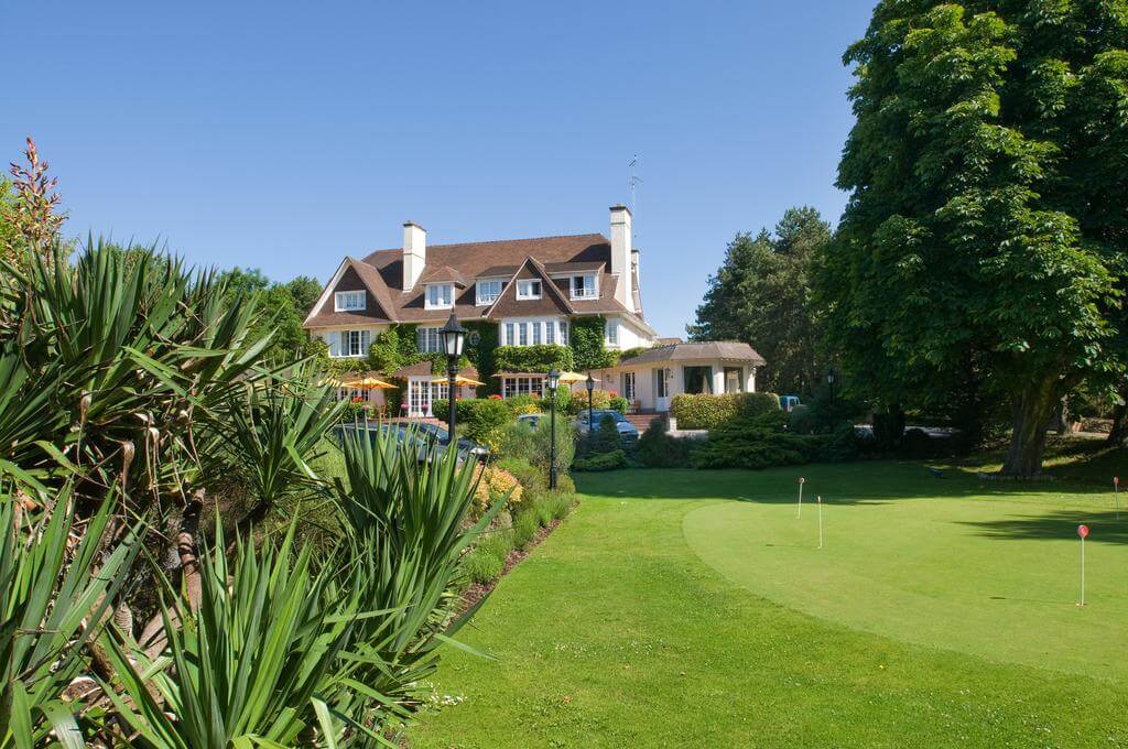 Practice putting green with Le Manoir Hotel in the distance