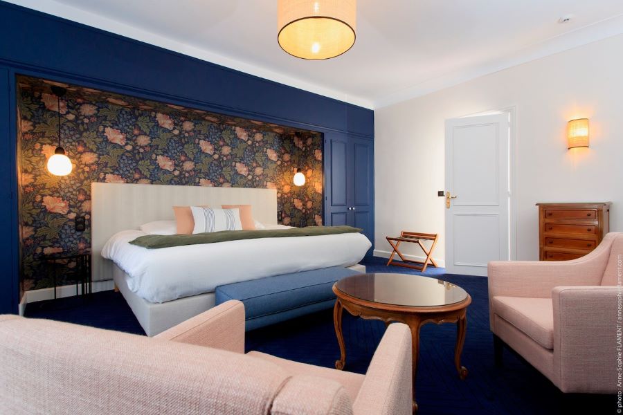 Bedroom at Le Manoir Hotel with chairs and table