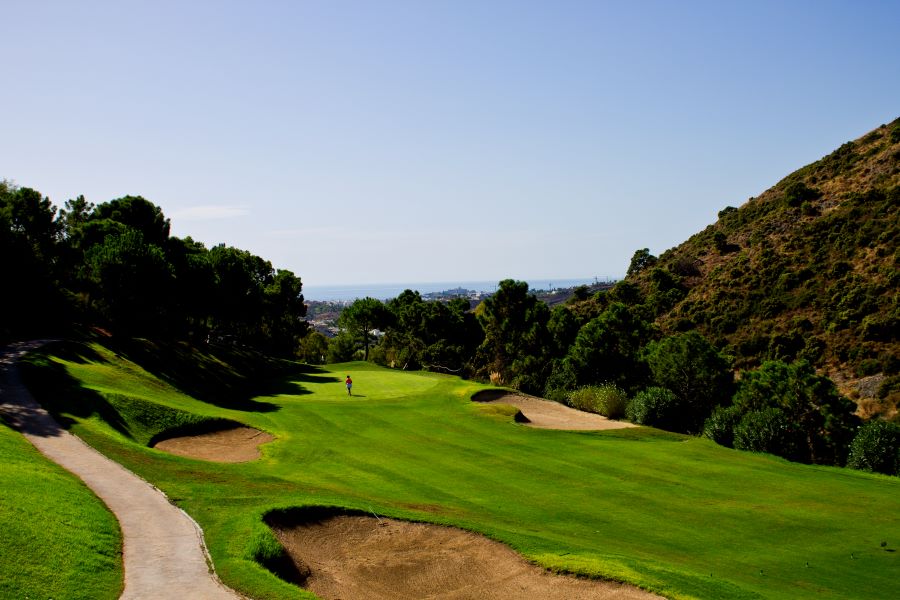 Bunker in foreground and trees either side of fairway at Los Arqueros Golf & Country Club