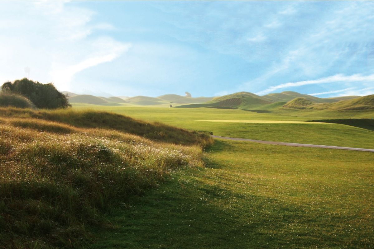 Light blue sky and clouds over the green fairway at Lykia Links