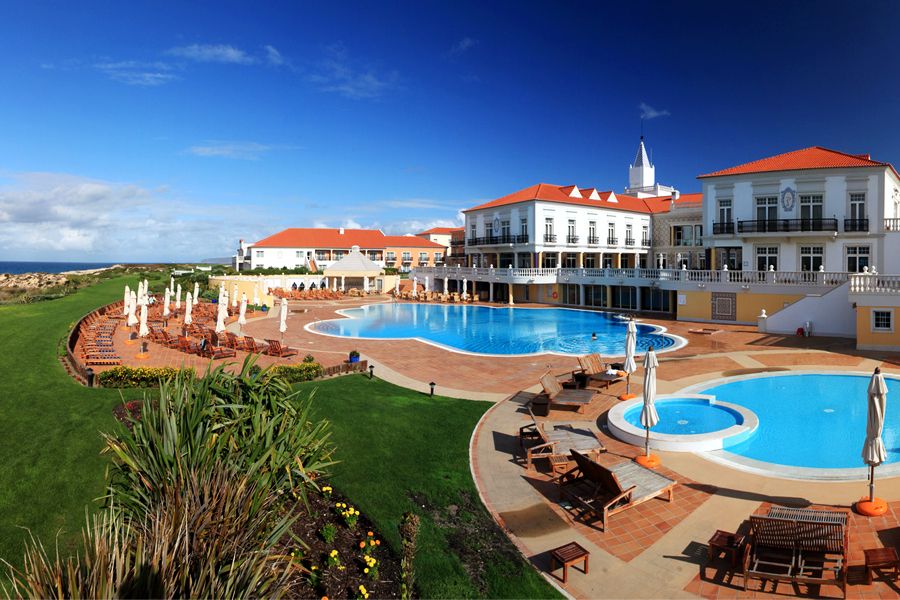 Swimming pool with sun loungers overlooking the sea at Marriott Praia D'El Rey Resort