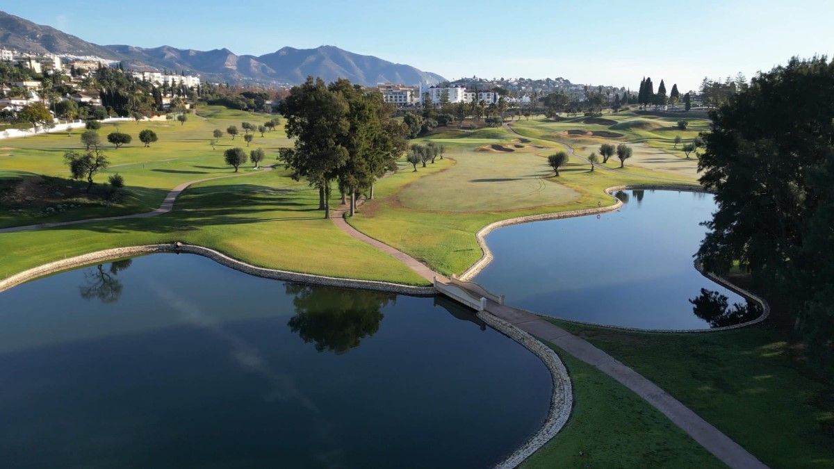 Large blue lake with bridge over it at Mijas Golf Club