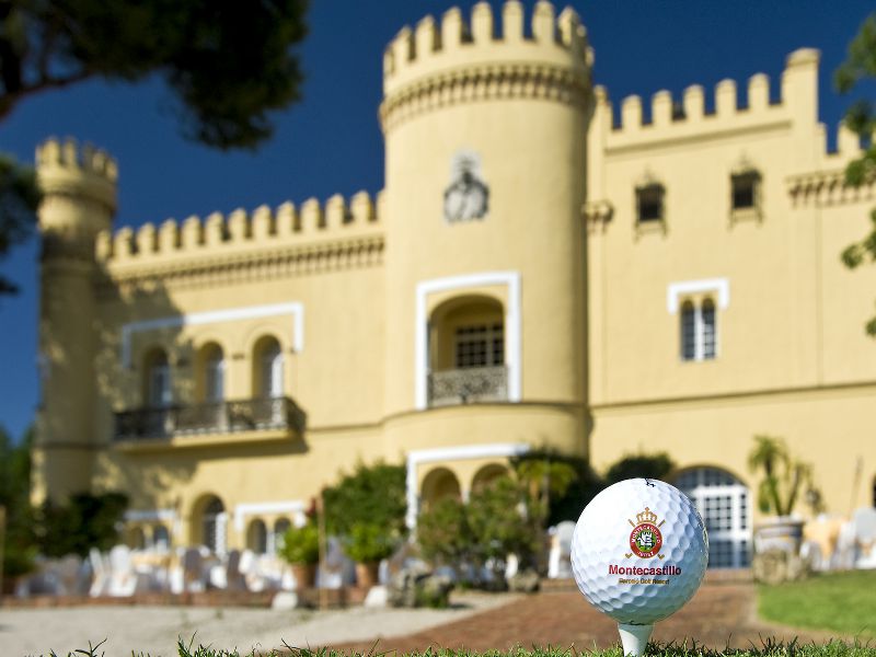 Exterior shot of Montecastillo Golf Resort in the background and a branded golf ball in the foreground
