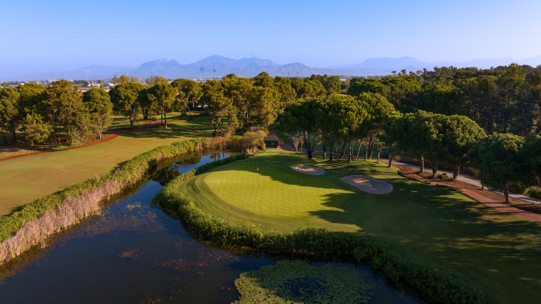 Putting green protected by blue water lake at National Golf Club in Turkey