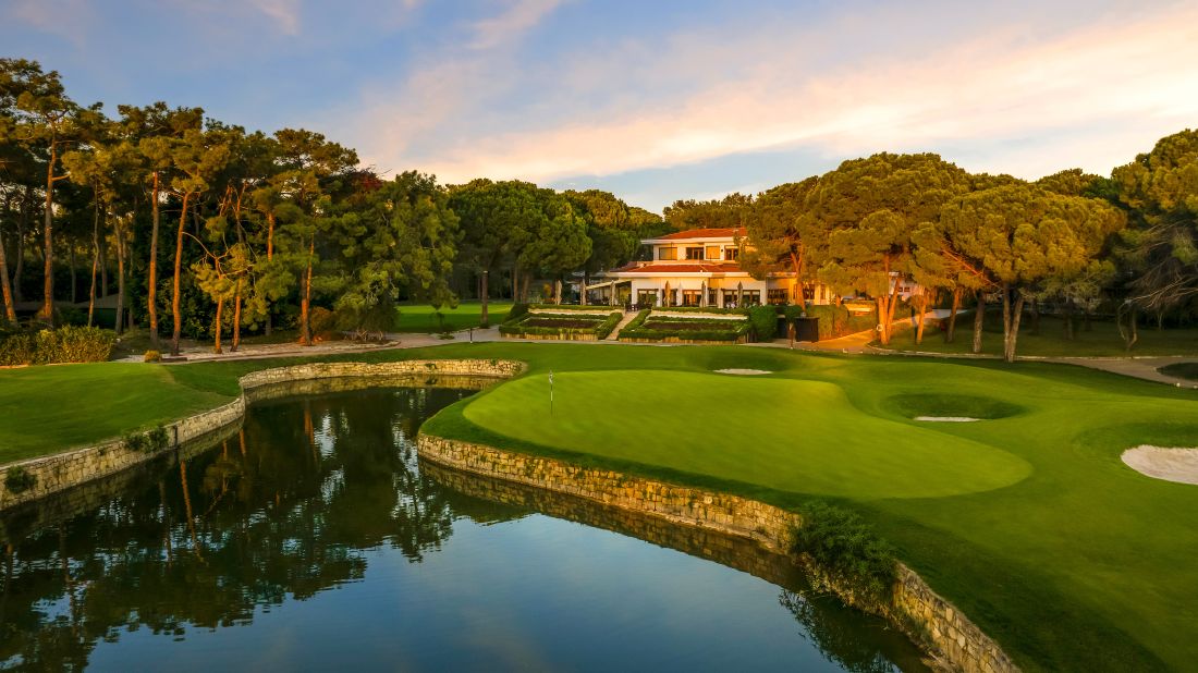 Club house at National Golf Club behind putting green