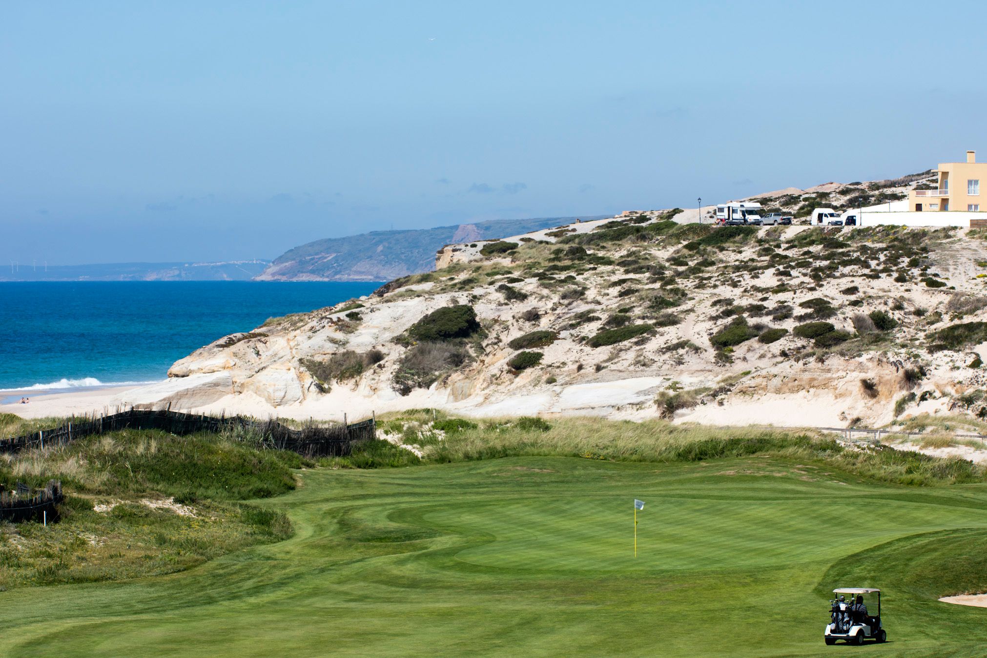 Praia D'El Rey Golf Course with golfer in a buggy approaching the green