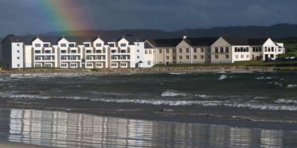 Exterior of Rosapenna Golf Resort with rainbow in the background and sea in the foreground