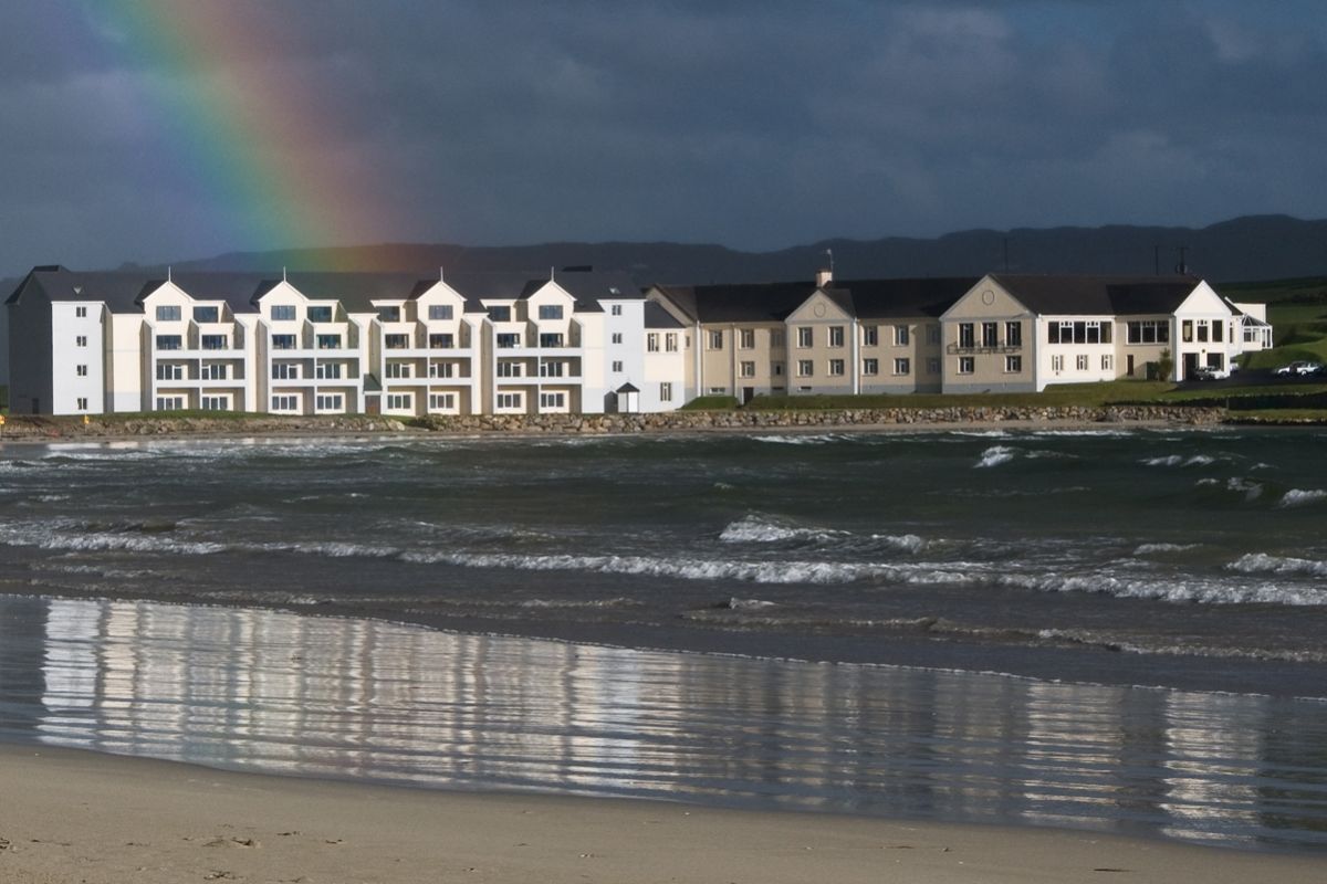 Exterior of Rosapenna Golf Resort with rainbow in the background and sea in the foreground