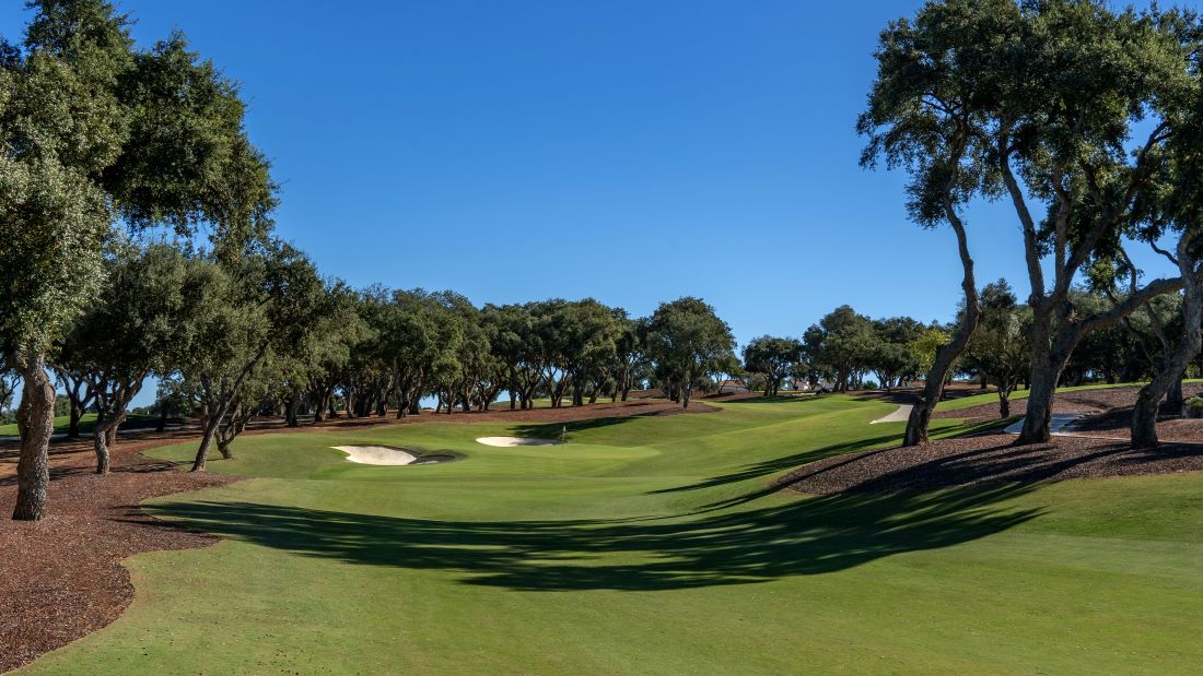 Blue sky and green trees surrounding Old Course at San Roque