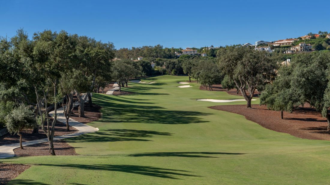 Up the fairway at San Roque Old Golf Course in Spain with trees and bunkers lining it
