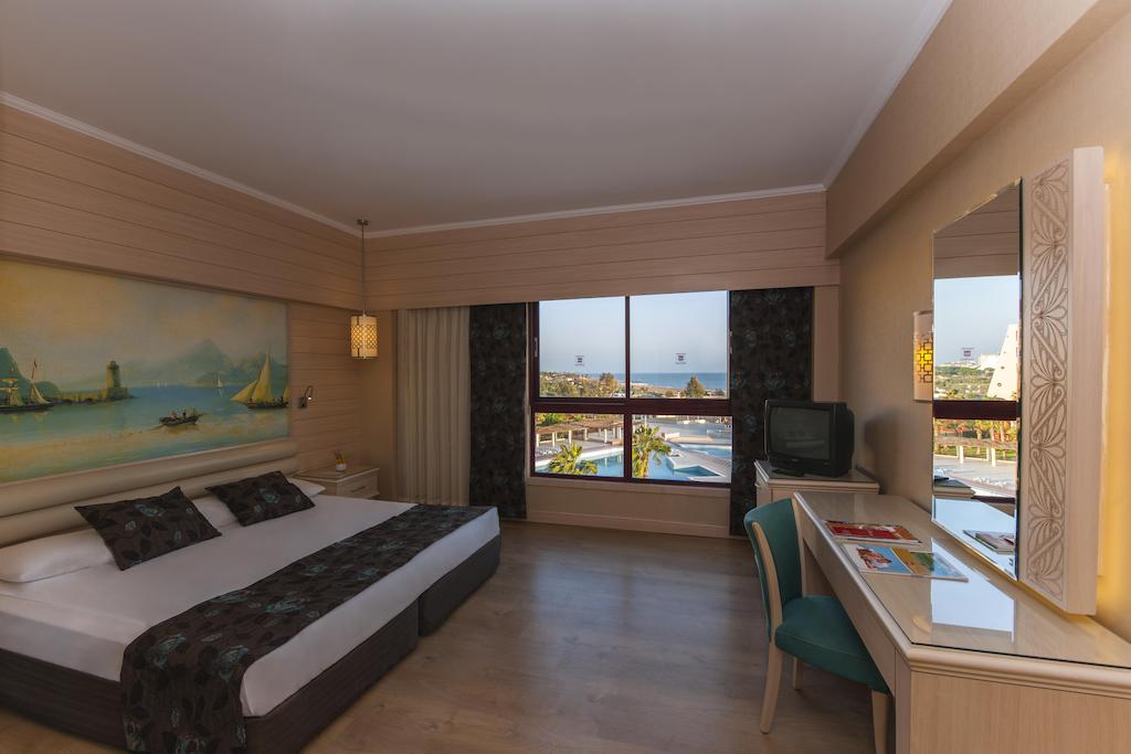 Double bedrrom with television and desk at Kaya Belek Hotel