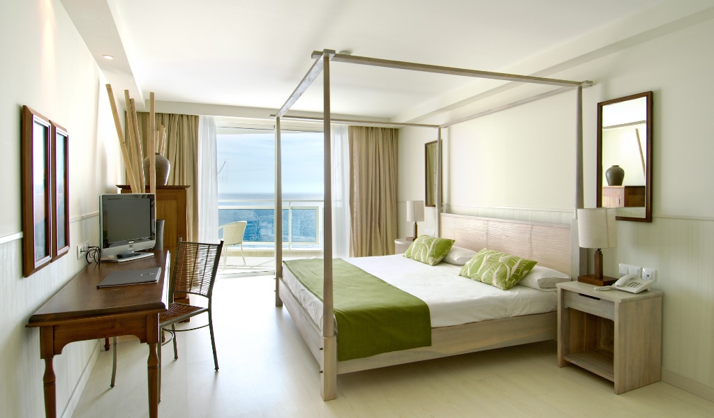Double bedroom at Vincci Tenerife Golf with four poster bed, wooden desk, television and private balcony