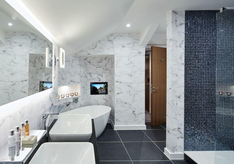 Bathroom at Formby Hall with twin sinks, shower cubicle and bath tub