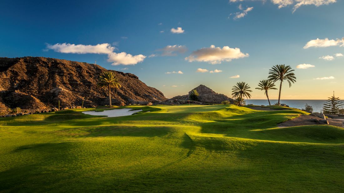 Green fairway and large rock to left at Anfi Tauro Golf Course in Spain's Gran Canaria