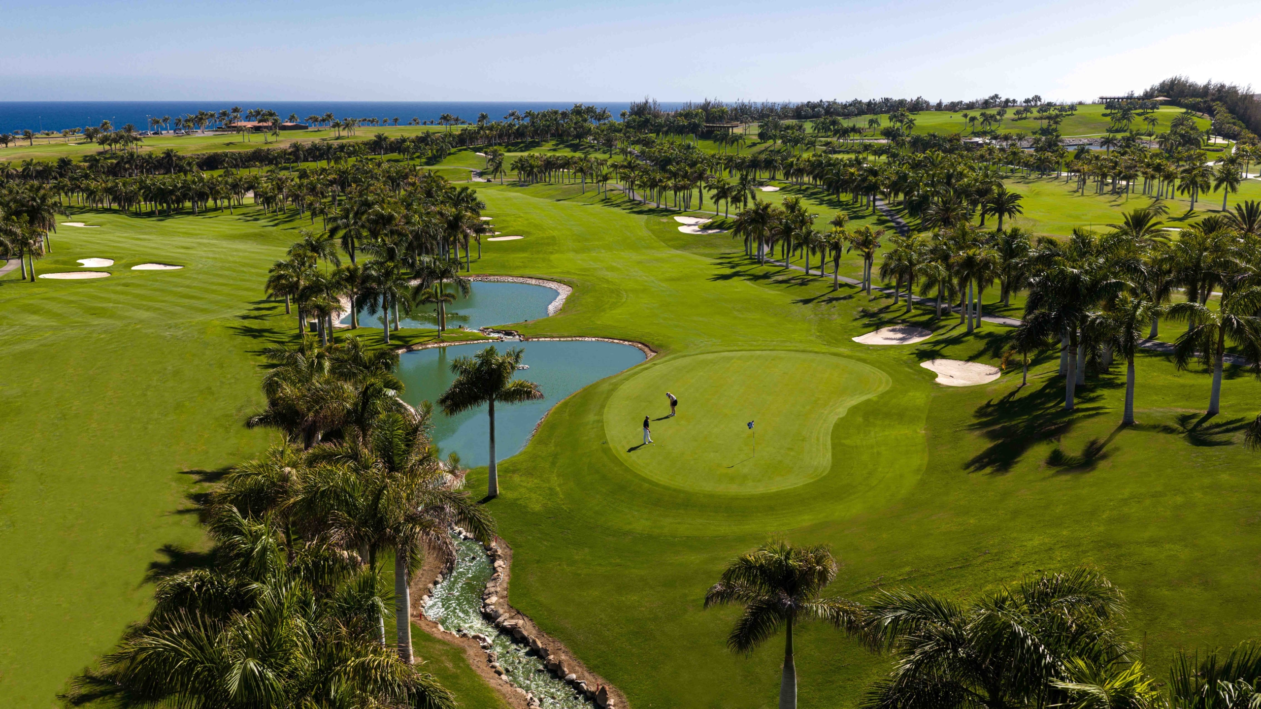 Lopesan Meloneras golf course in Gran Canaria with lakes and palm trees on the left