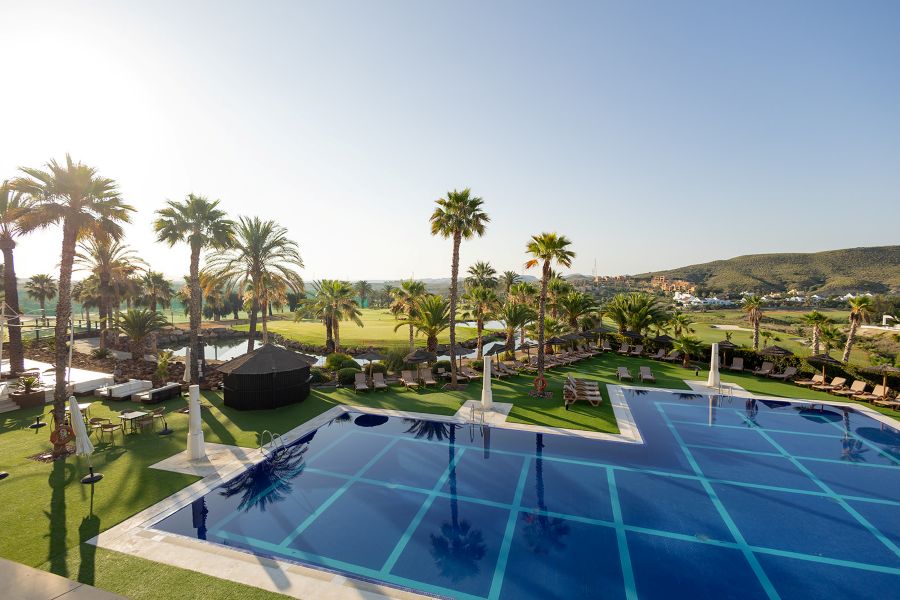 Swimming pool with palm trees overlooking the golf course at Valle Del Este Golf Resort