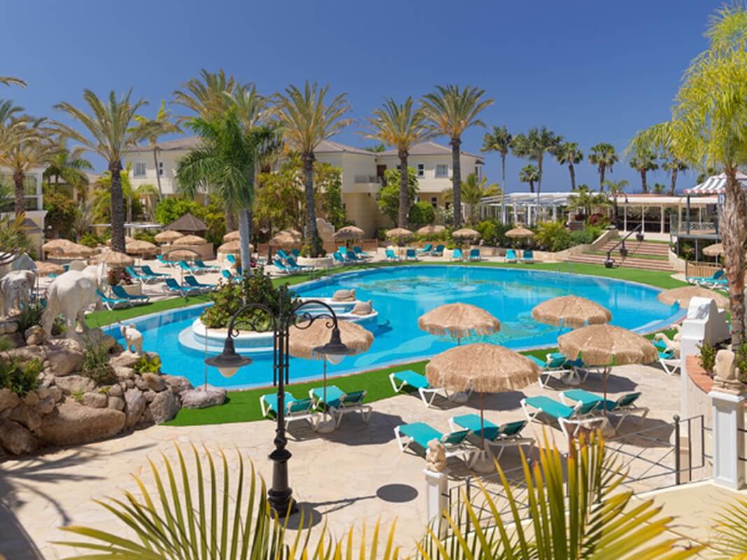 Gran Oasis Resort's swimming pool with sun loungers, parasols, and palm trees