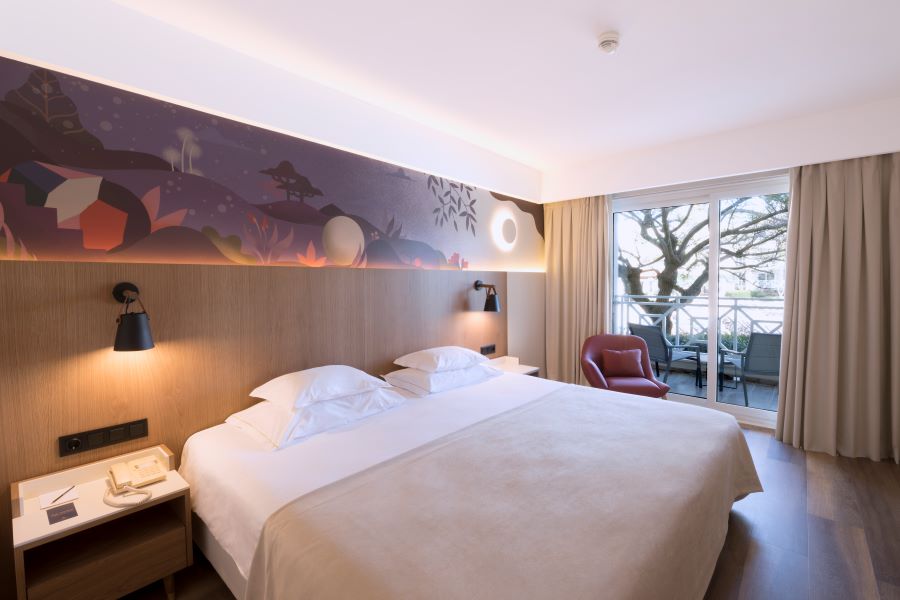 Bedroom with double bed and balcony view of golf course at Quinta Da Marinha resort in Cascais, Lisbon