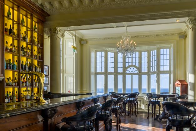 Bar with leather stools at Trump Turnberry Golf Resort and views of the golf course
