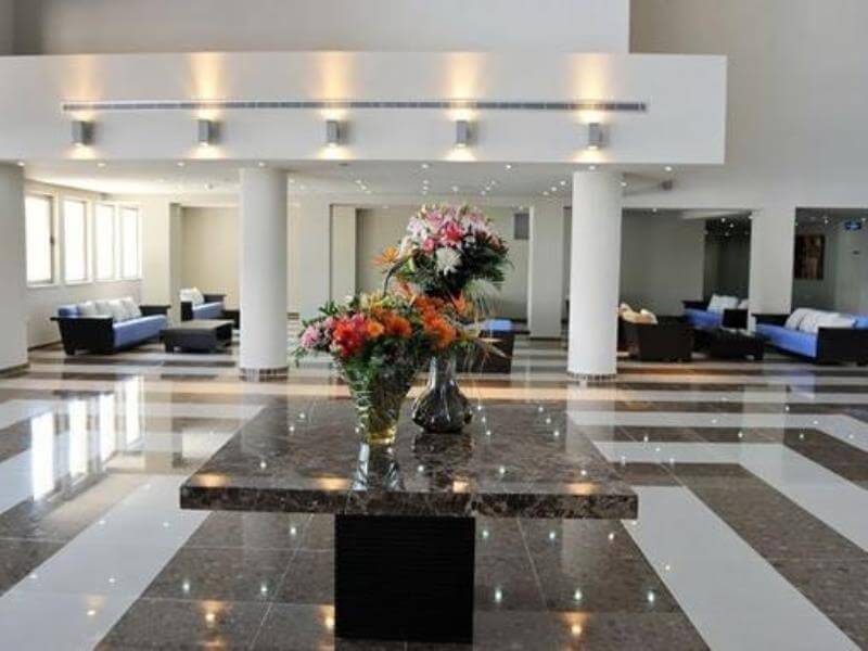 Lobby areas in Capital Coast Resort And Spa with flowers decorating the table on marble floor