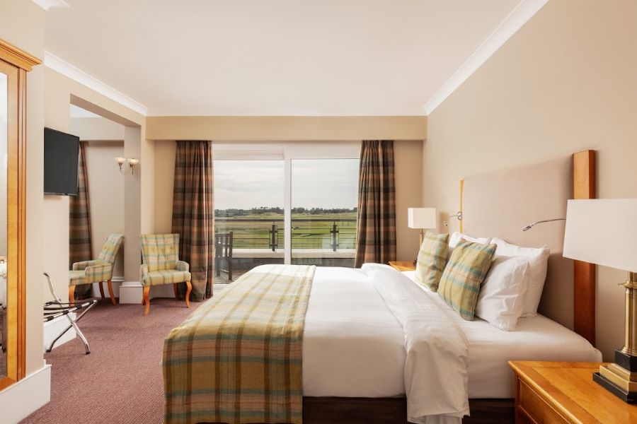Bedroom at Carnoustie Golf Hotel & Spa with double bed and view of the golf course