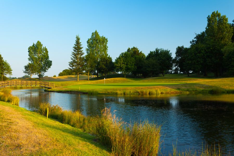 Blue water lake acting as a hazard on the golf course at Dunston Hall Golf And Spa