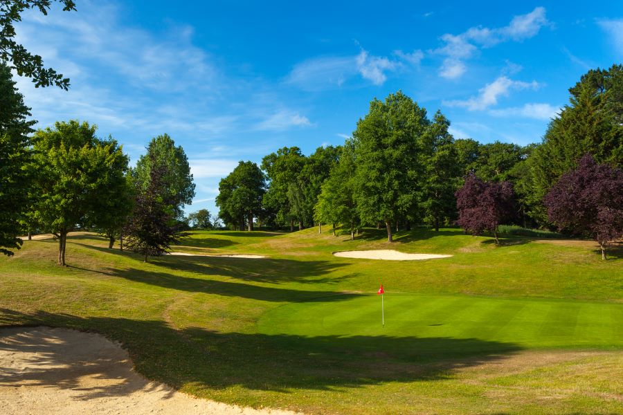 Large trees and sand bunker behind the green at Dunston Hall Golf And Spa