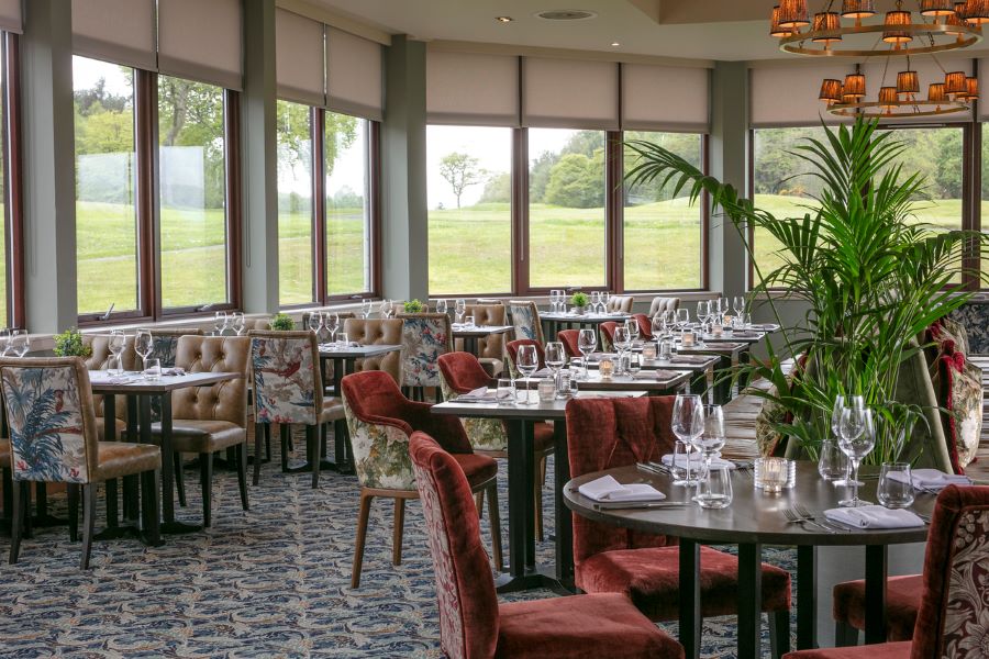 Restaurant tables with view over the golf course at Glasgow Westerwood Hotel, Spa & Golf Resort