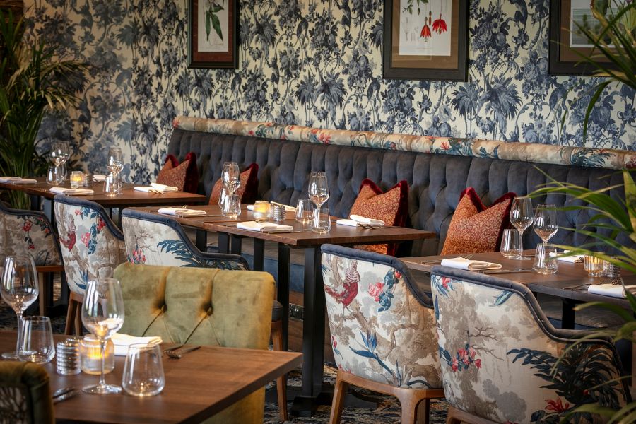 Dining room with chairs and bench seating ready for service at Glasgow Westerwood Hotel, Spa & Golf Resort