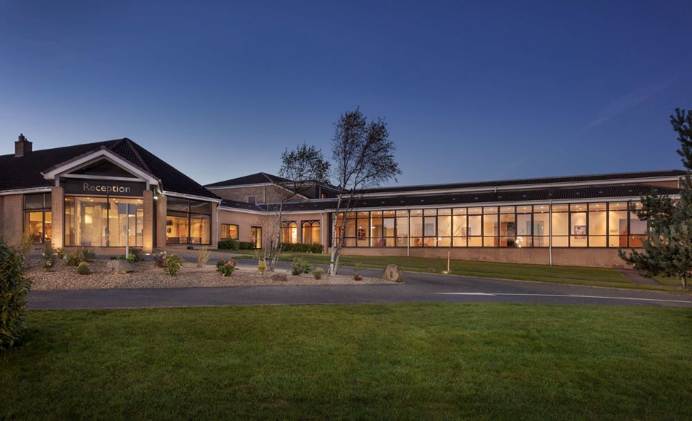Exterior of Glasgow Westerwood Hotel, Spa & Golf Resort lit up at night