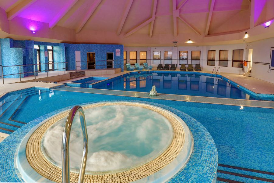 Jacuzzi in purple lit spa at Glasgow Westerwood Hotel, Spa & Golf Resort