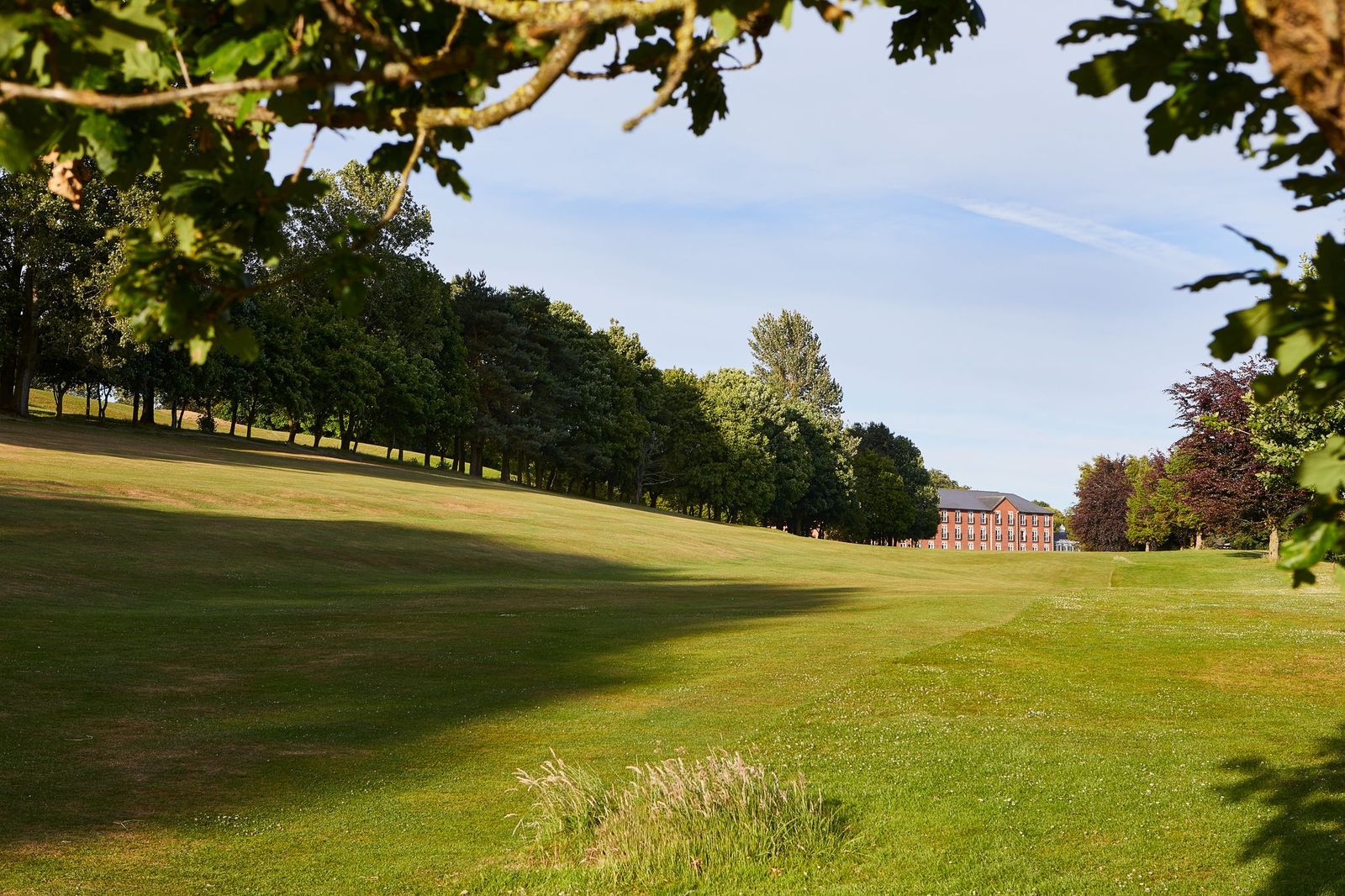 Curved fairway with hotel in the distance at Macdonald Hill Valley Hotel Golf & Spa