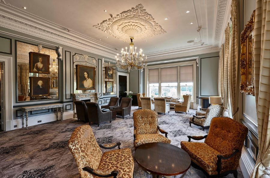 Lounge with numerous tables and chairs with luxury décor at Oulton Hall Golf Hotel And Spa