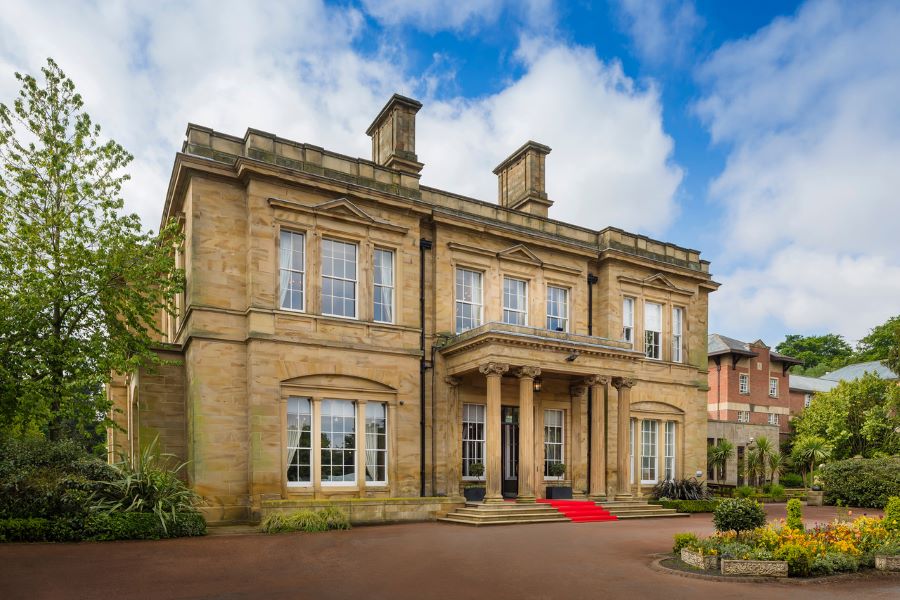 Entrance of Oulton Hall Golf Hotel And Spa with red carpet up steps