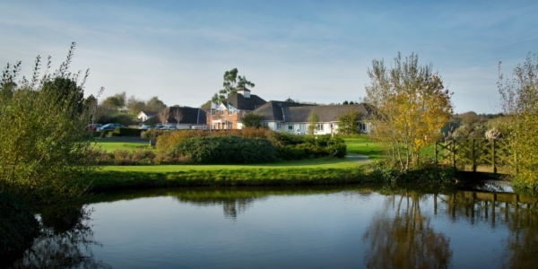 Main hotel with lake in foreground at Sandford Springs Golf Resort